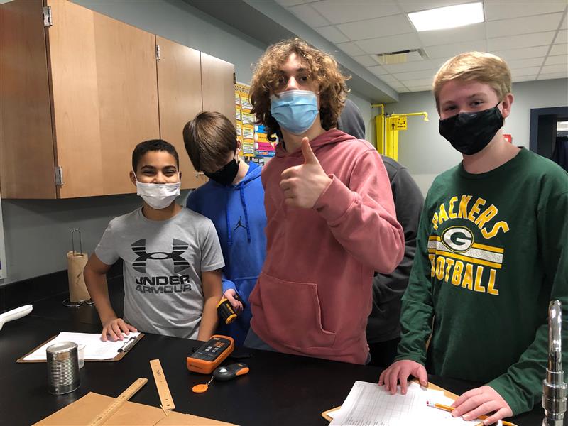 Student with thumbs up and others behind him