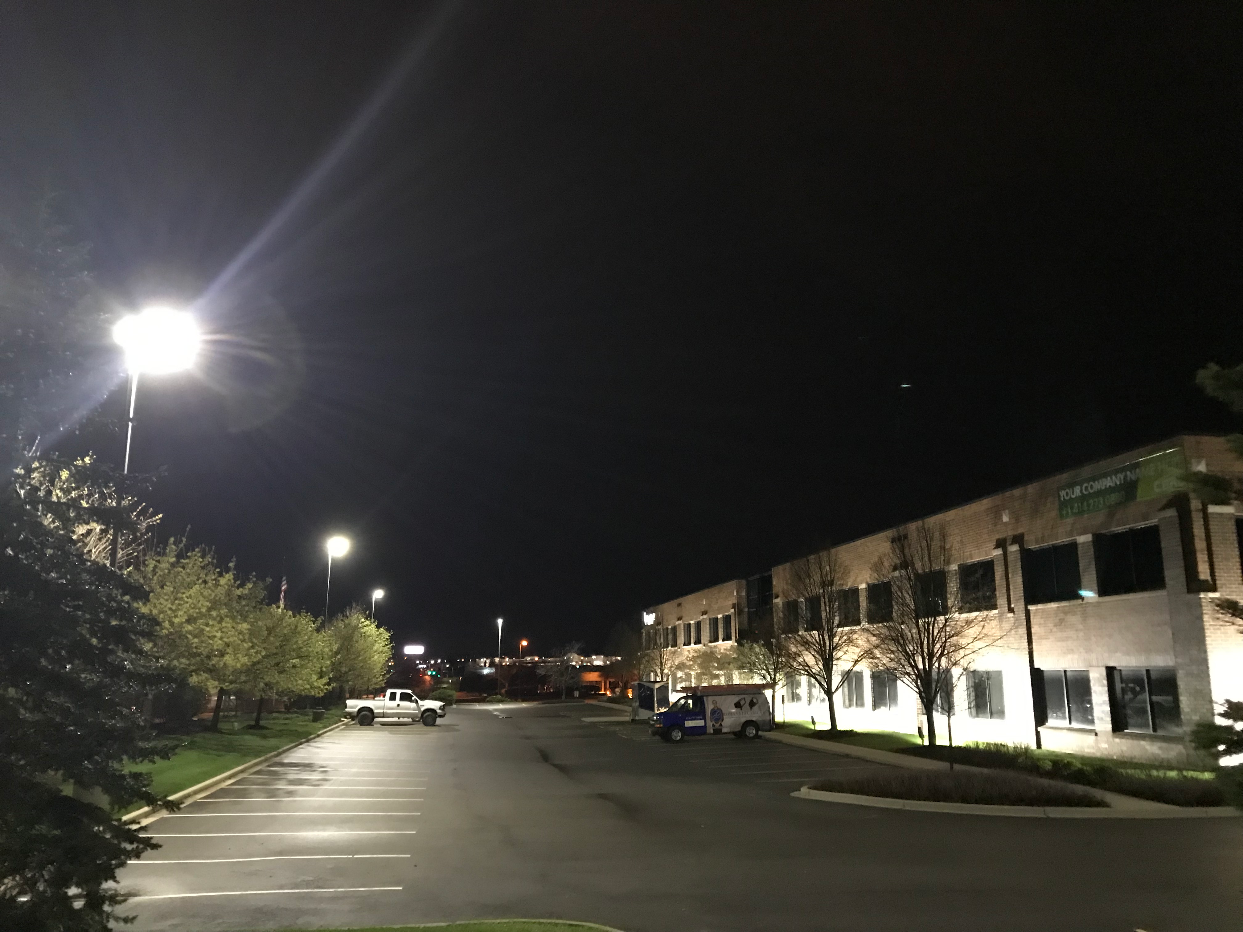 Exterior shot of a commercial building at night, including the building's parking lot.